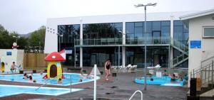 a building with a pool with people in it at Selfoss Apartment in Selfoss