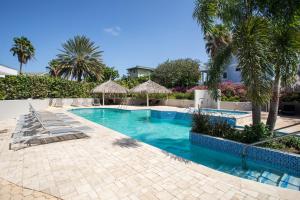 una piscina con palmeras y un complejo en Casa Pacifico, en Willemstad