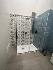 una ducha con puerta de cristal en un baño en Dimora Chiaia 209, en Nápoles