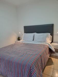 a bedroom with a bed with a striped comforter at Hermoso departamento con patio en Rio Gallegos in Río Gallegos