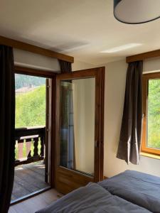 a bedroom with a bed and a sliding glass door at Ferientreff-Stilfs in Stelvio