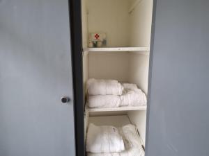 un armario con toallas blancas en un estante en Hermoso departamento con patio en Rio Gallegos en Río Gallegos