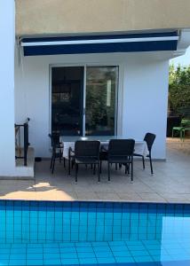 eine Terrasse mit einem Tisch und Stühlen neben einem Pool in der Unterkunft Holiday Home Emba in Emba