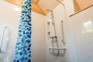 a shower with a blue and white shower curtain at Wigwam Holidays Forcett Grange in Richmond