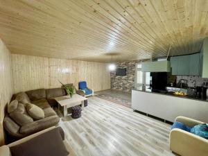 a living room with a couch and a kitchen at Tvaliakari in Khulo