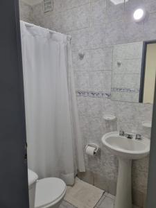 baño con cortina de ducha blanca y lavamanos en Hermoso departamento con patio en Rio Gallegos en Río Gallegos