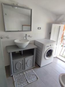 a bathroom with a washing machine and a sink at La manSarda in Tortolì