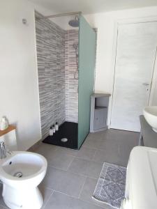 a bathroom with a shower and a toilet and a sink at La manSarda in Tortolì