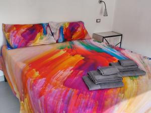 a multicolored bed with two black controllers on it at La manSarda in Tortolì