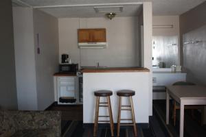 eine Küche mit zwei Barhockern und einer Arbeitsplatte in der Unterkunft Lake Erie Lodge in Lakemont Landing