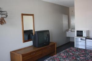 um quarto com televisão numa cómoda com espelho em Lake Erie Lodge em Lakemont Landing