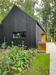 a black house with a garden in front of it at Skoft in Siegerswoude