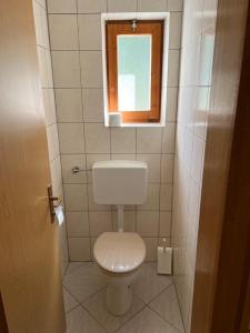 a small bathroom with a toilet and a window at Ferientreff-Stilfs in Stelvio