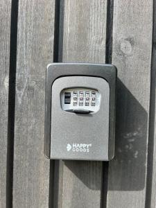 uma caixa de correio com um botão feliz numa parede de madeira em It Skoft em Siegerswoude