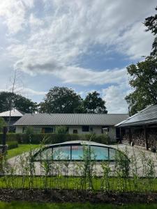 une maison avec une piscine dans une cour dans l'établissement It Skoft, à Siegerswoude