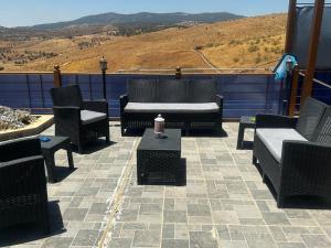 - un ensemble de chaises et de tables sur une terrasse dans l'établissement Jarash farm, à Jerash