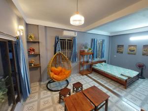a living room with a hanging bed and a table at alley homestay in Hanoi