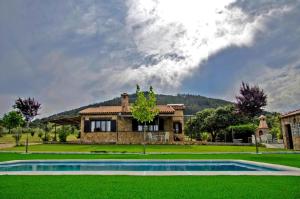 a house with a swimming pool in front of it at CR El Portezuelo Boutique Experience in Fuentelabrada de los Montes