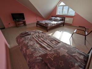 een slaapkamer op zolder met een bed en een bank bij Гостиный дом 