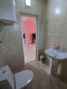 een badkamer met een wastafel, een toilet en een spiegel bij Гостиный дом 