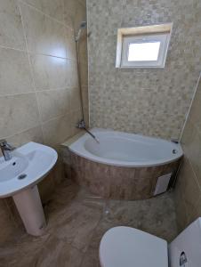 een badkamer met een bad, een toilet en een wastafel bij Гостиный дом 