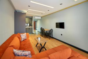 a living room with an orange couch and a table at Sofyapart in Soğuksu