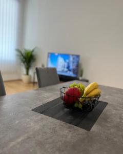 a basket of fruit on a table with a laptop at Modernes Juwel in zentraler Lage in Vienna