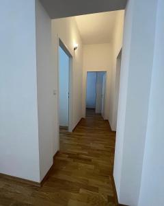 an empty hallway with white walls and wood floors at Modernes Juwel in zentraler Lage in Vienna