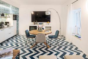 a kitchen with a table and chairs on a blue and white floor at Costa Del Capitano Seaside Villas in Ischia