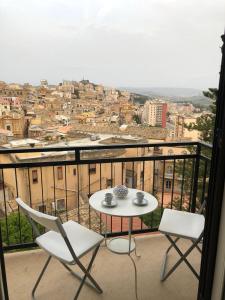 a table and chairs on a balcony with a view at Kalé Atenea in Agrigento