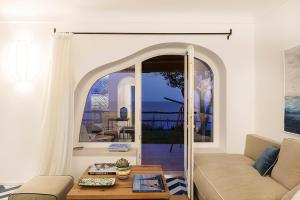 a living room with a couch and a table at Costa Del Capitano Seaside Villas in Ischia