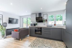 a kitchen with a couch and a chair in a room at Stunning 6 Bed 3 Bath Detached Home in Cheltenham in Golden Valley