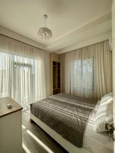 a bedroom with a bed and a large window at Aparthotel Kutaisi in Kutaisi