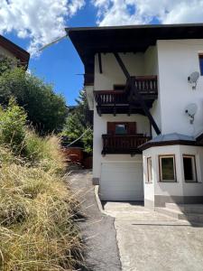 a white house with a balcony and a garage at Ferientreff-Stilfs in Stelvio