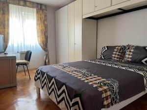 een slaapkamer met een bed, een bureau en een raam bij Domestico apartment in Rijeka