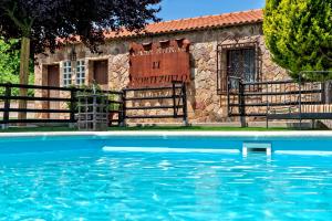 a house with a swimming pool in front of a building at CR El Portezuelo Boutique Experience in Fuentelabrada de los Montes