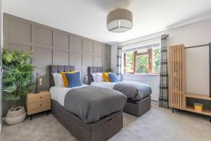 a bedroom with two beds and a window at Stunning 6 Bed 3 Bath Detached Home in Cheltenham in Golden Valley