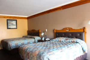 a hotel room with two beds in a room at Executive Inn Goliad in Goliad