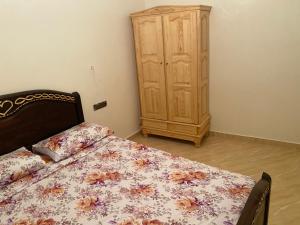 Schlafzimmer mit einem Bett und einem Holzschrank in der Unterkunft Lotissment oum kaltoum 2 in Martil