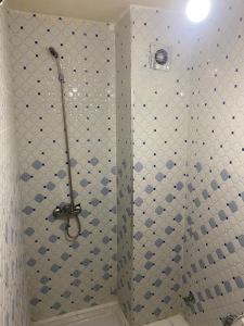 eine Dusche im Bad mit blauen und weißen Fliesen in der Unterkunft Lotissment oum kaltoum 2 in Martil