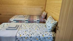 a bedroom with two beds with pillows and a door at Gurgeniani Twin Cottages in Lagodekhi