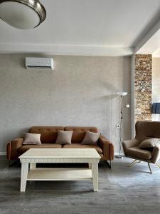 a living room with a couch and a coffee table at Aparthotel Kutaisi in Kutaisi