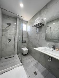 a bathroom with a shower and a toilet and a sink at Hotel Stolis in Himare