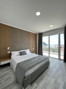 a bedroom with a large bed and a large window at Hotel Stolis in Himare