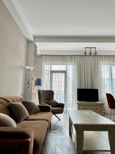 uma sala de estar com um sofá e uma televisão em Aparthotel Kutaisi em Kutaisi