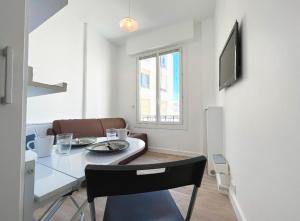 a dining room with a table and chairs and a window at Cosy studio ensoleillé - centre-ville – TRAM/AC in Nice