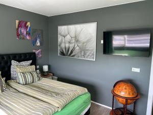 ein Schlafzimmer mit einem Bett und zwei Bildern an der Wand in der Unterkunft Eskivellir 11 in Hafnarfjördur