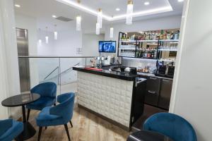 a bar with blue chairs and a counter at Hotel Saint Christophe in Calvi