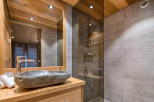 a bathroom with a stone sink and a shower at Chalet Canopée in Demi-Quartier +23 photos