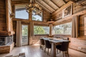 a dining room with a table and chairs and a fireplace at Chalet Canopée in Demi-Quartier